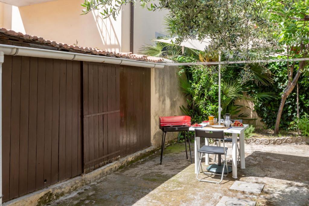 patio ze stołem i ogrodzeniem w obiekcie Cisanello Rock Apartment with Patio and Barbecue w Pizie