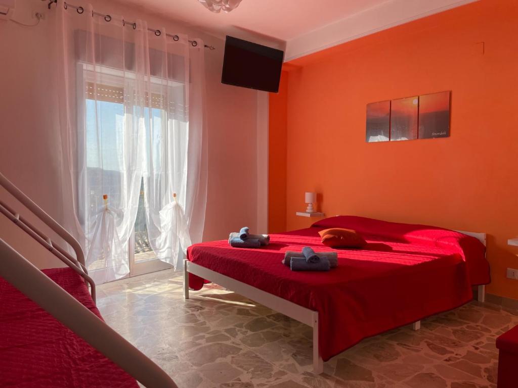 Un dormitorio rojo con una cama roja y una ventana en La casa di Aba, en Il Casale
