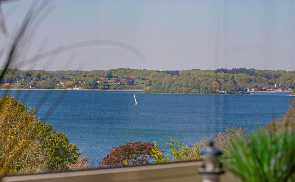 a view of a lake with a boat in the water at fewo1846 - Del Mar - komfortable 2-Zimmer-Wohnung mit Balkon im 7 OG in Glücksburg