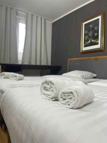 a bedroom with two white towels on a bed at Hotel Bentley New in Brussels