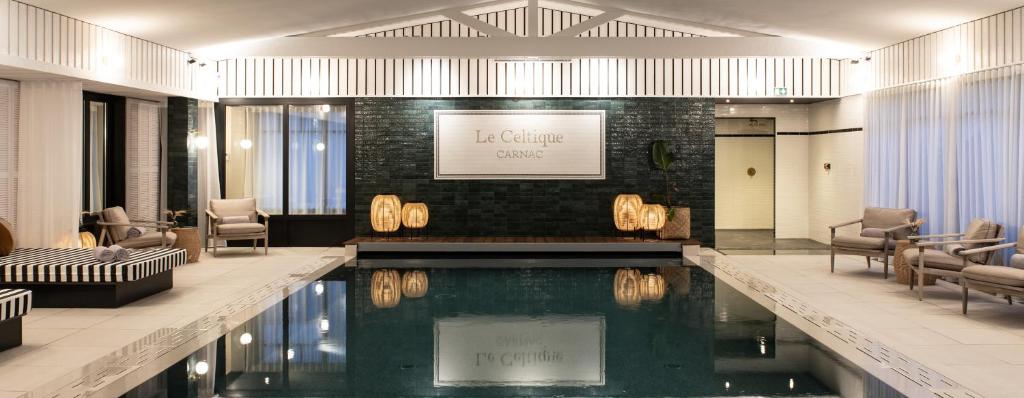 un hall d'hôtel avec une piscine au milieu dans l'établissement Le Celtique & Spa, à Carnac