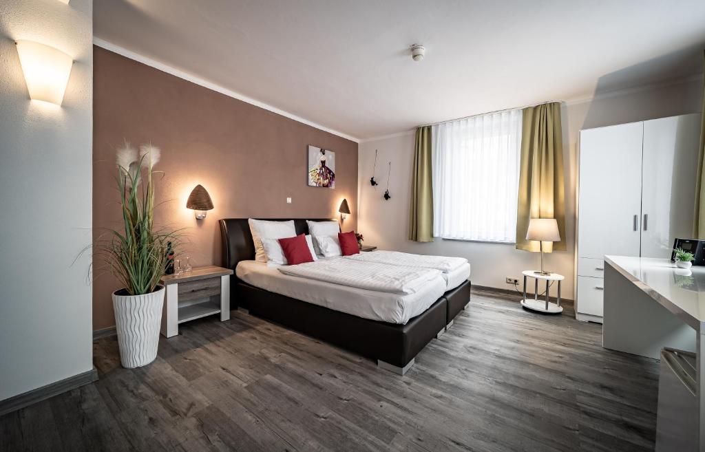 um quarto de hotel com uma cama e uma janela em Le petit Palais - Hotel/Pension em Bad Suderode