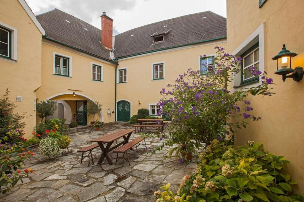 einen Innenhof eines Gebäudes mit Bänken und Blumen in der Unterkunft Gästehaus Huber in Weissenkirchen in der Wachau