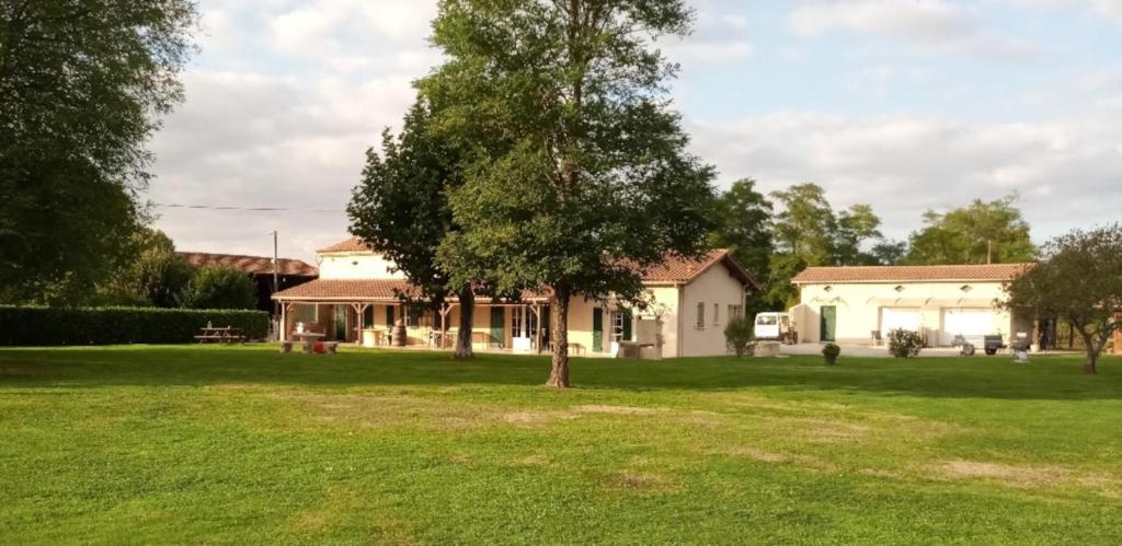 una casa con un árbol en el patio en La Mancine Laulan, en Jau-Dignac-et-Loirac