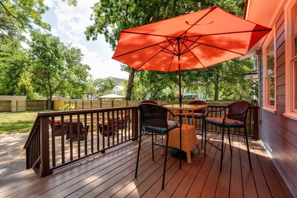 eine Terrasse mit einem Tisch, Stühlen und einem Sonnenschirm in der Unterkunft Pinwheel Place in Jacksonville