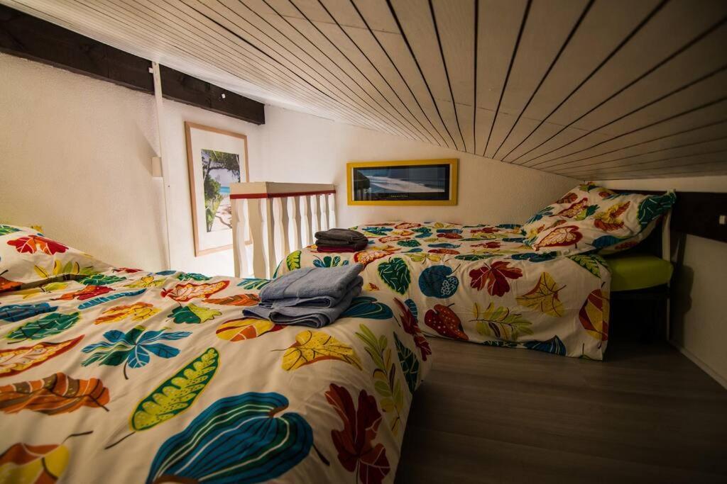a bedroom with two beds with colorful comforters at Appartement Seignosse le Penon/plage in Seignosse