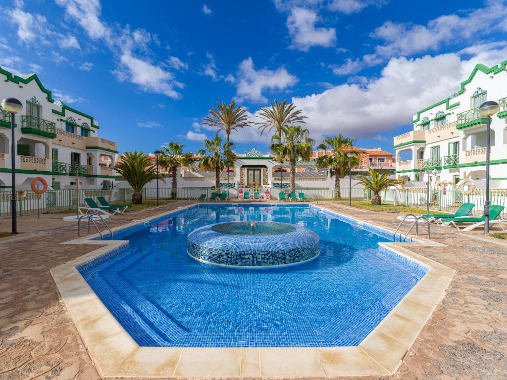 a swimming pool with a fountain in the middle at HomeForGuest Apartamento con Piscina en Caleta de Fuste in Caleta De Fuste