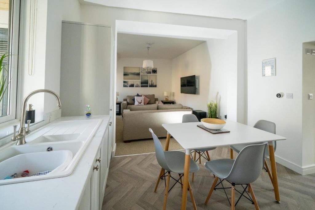 cocina con mesa, sillas y fregadero en 'The Retreat' - Stylish one bedroom apartment in Holt, Norfolk en Holt