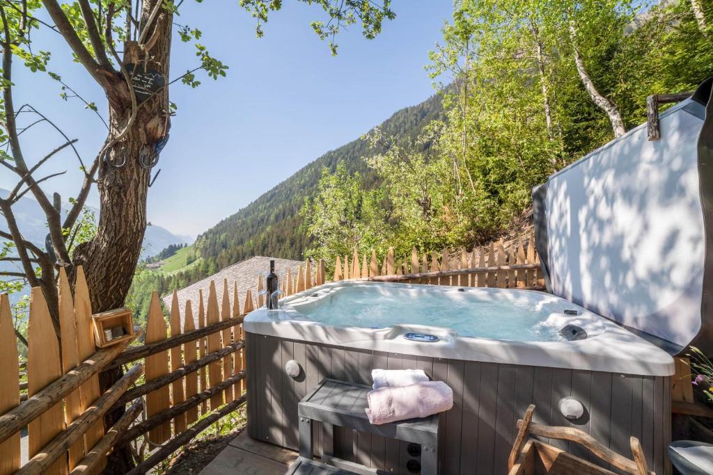 a jacuzzi tub with a mountain in the background at Fewo Bergpanorama Obertalerhof in San Martino