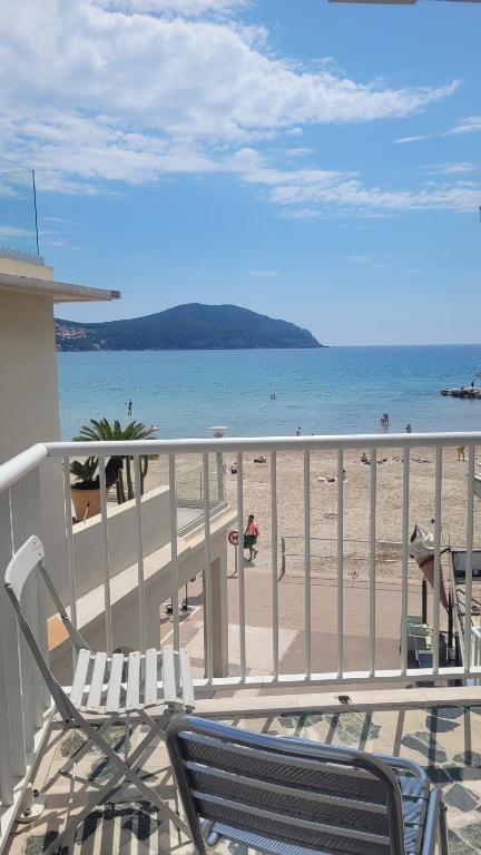 a balcony with a view of a beach with chairs at Les Pieds dans l'Ô - Appartement 50m2 Front de mer in Saint-Cyr-sur-Mer