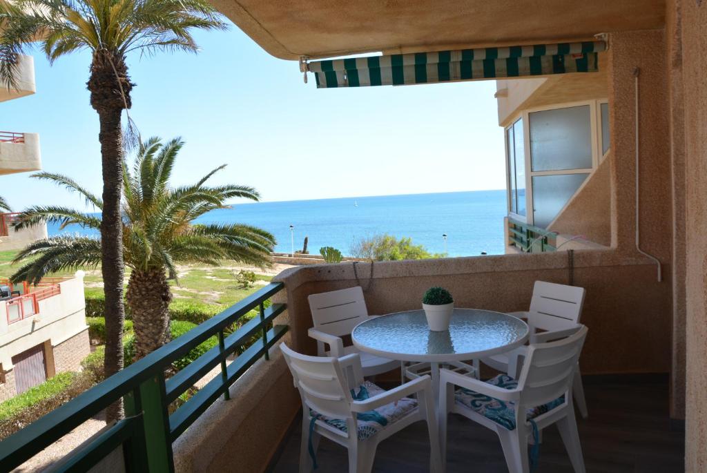 d'un balcon avec une table et des chaises donnant sur l'océan. dans l'établissement El Apartamento De Papá - Mil Palmeras, à Orihuela Costa