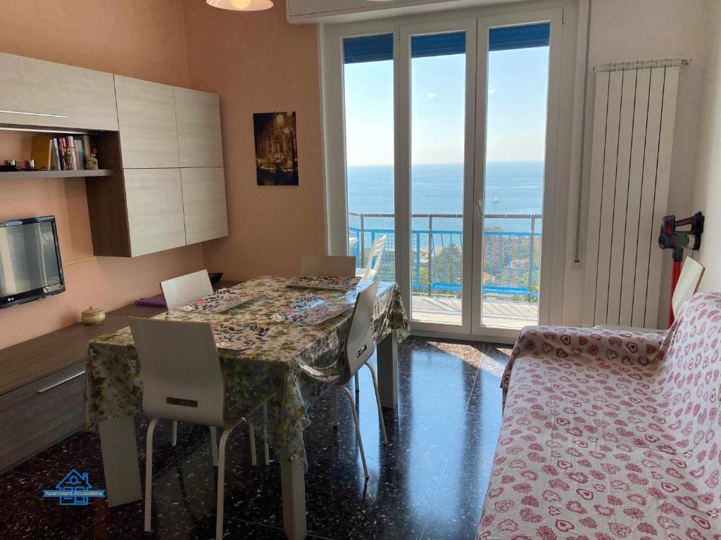 uma cozinha com mesa e cadeiras e uma varanda em Apartament Arcobaleno a 500 metri dal mare em Albissola Marina