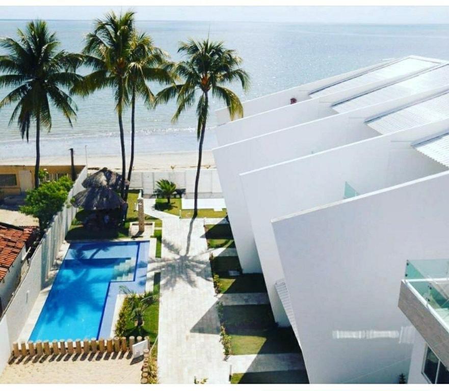 an aerial view of a resort with a swimming pool and the beach at Maria Farinha Residence Prince - LocarHouse in Paulista