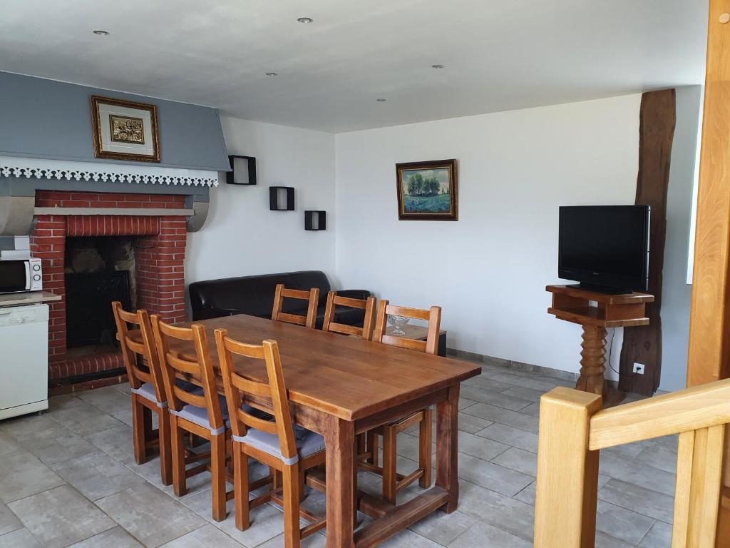 a kitchen and dining room with a wooden table and chairs at Gîte du ronthaunay in Saint-Clément