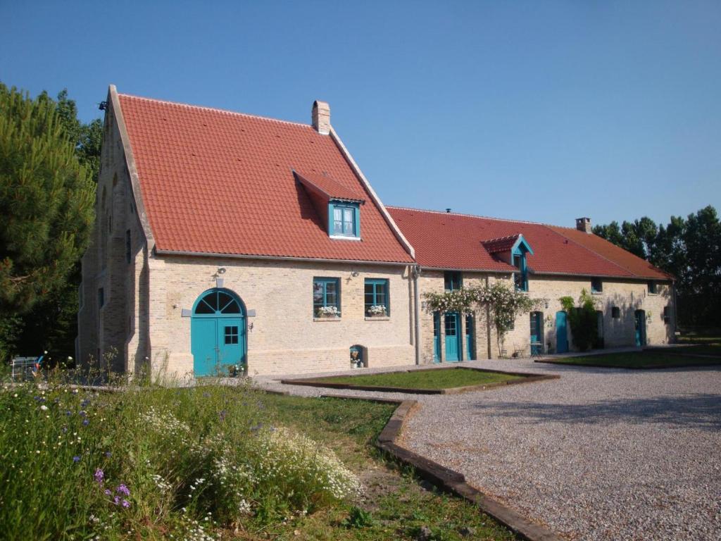 ein großes weißes Gebäude mit rotem Dach in der Unterkunft Gîte Quaëdypre, 4 pièces, 6 personnes - FR-1-510-171 in Quaëdypre