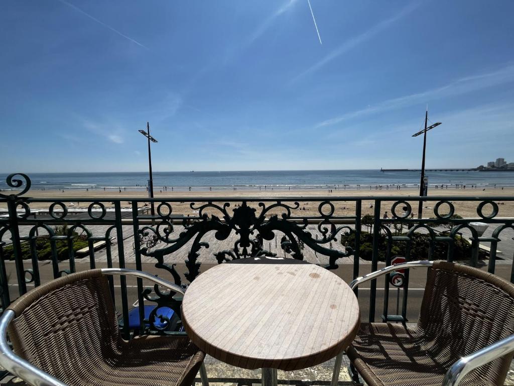 d'une table et de chaises sur un balcon donnant sur la plage. dans l'établissement Appartement Les Sables-d'Olonne, 2 pièces, 4 personnes - FR-1-197-536, à Les Sables-dʼOlonne