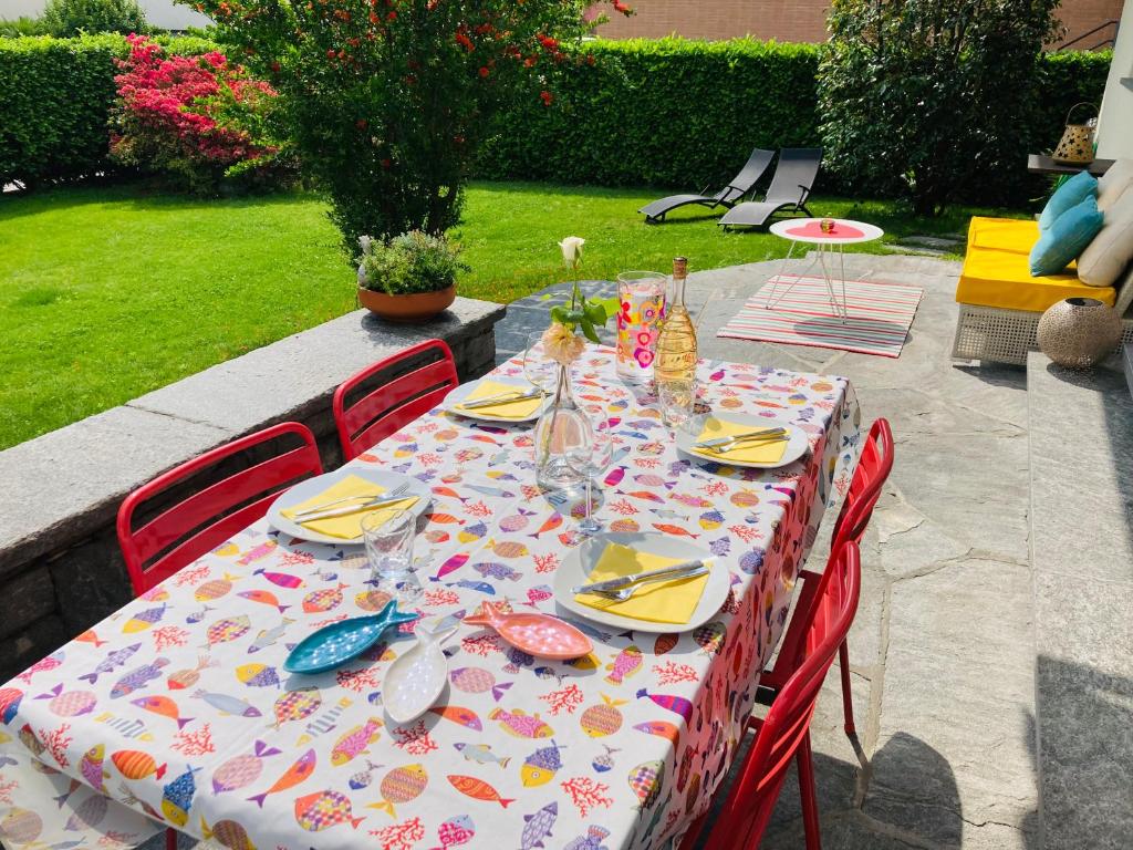 una mesa con sillas y un mantel con comida. en Appartamento con giardino al Melograno en Locarno