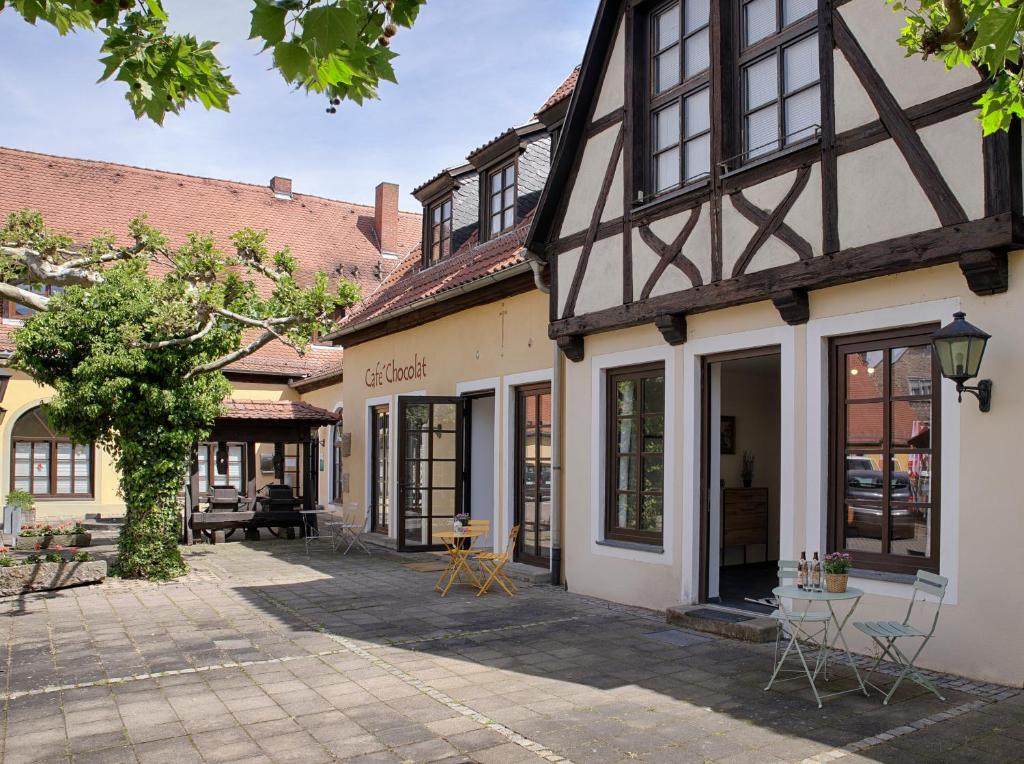 a building with a courtyard with tables and chairs at Fewos zur Alten Brauerei - am Main Ochsenfurt - by homekeepers in Ochsenfurt