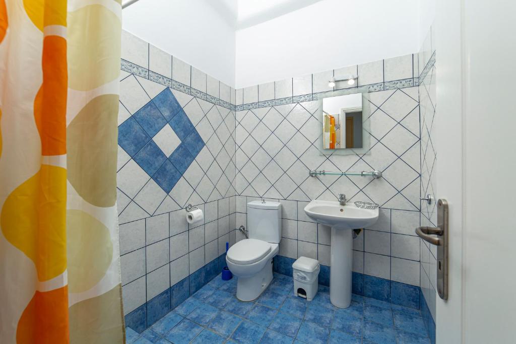 a bathroom with a toilet and a sink at Spertos Apartments in Órmos