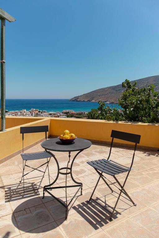 a table and chairs on a patio with a view of the ocean at Spertos Apartments in Órmos