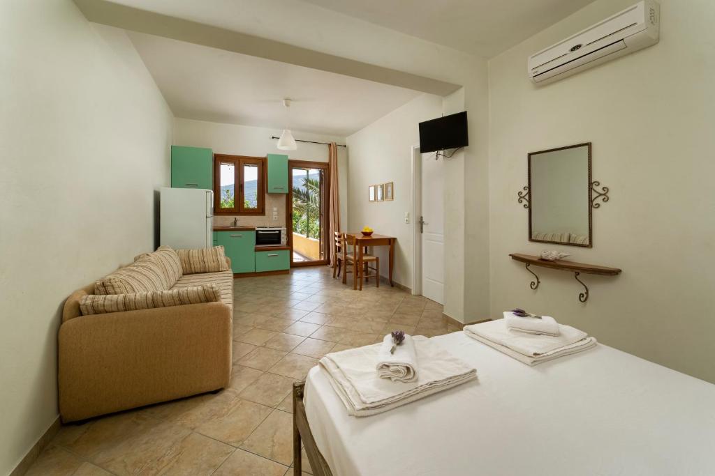 a living room with a couch and a table with towels at Spertos Apartments in Órmos