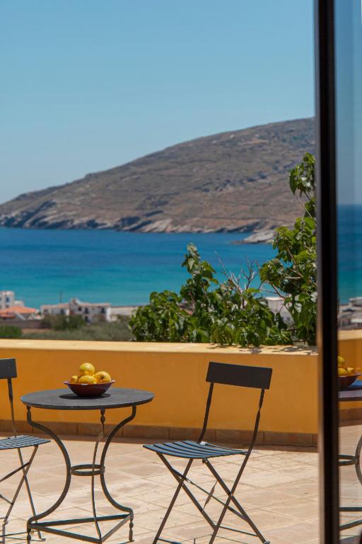 a table and chairs on a balcony with a view of the ocean at Spertos Apartments in Órmos