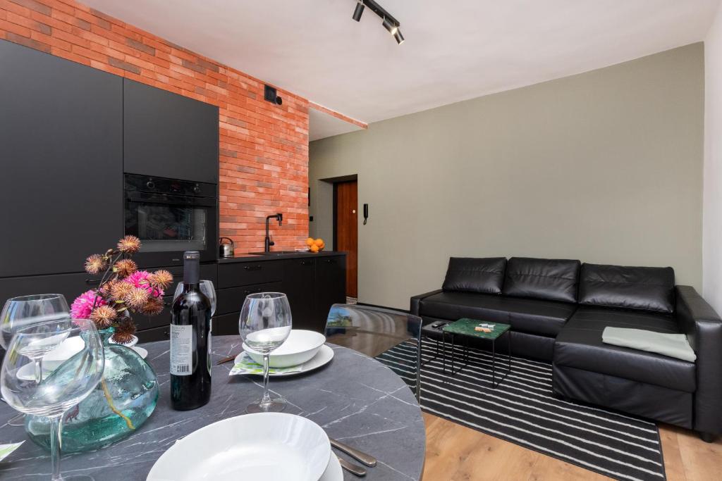 a living room with a couch and a table with wine glasses at Port Gdynia Apartment by Renters in Gdynia