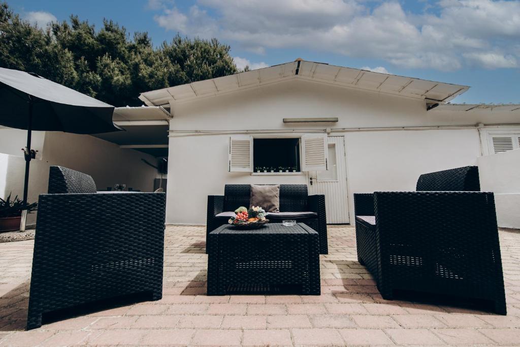 a patio with chairs and a table and an umbrella at Saturo Apartments in Leporano
