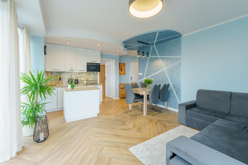 salon i kuchnia z kanapą i stołem w obiekcie Apartament Doro w Kołobrzegu