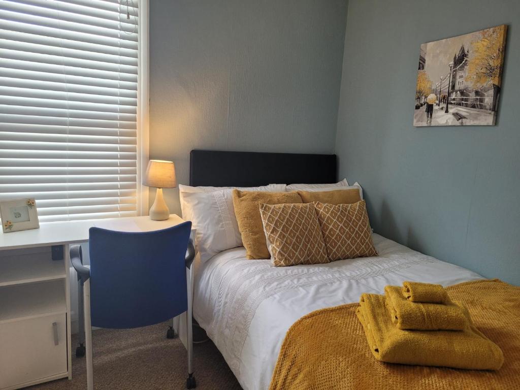 a bedroom with a bed with a desk and a desk at Garfield Road in Gillingham