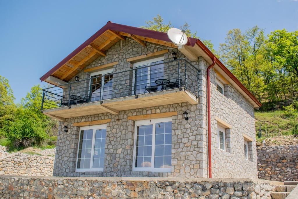 a stone house with a balcony on a stone wall at Villa Grkasha in Ohrid
