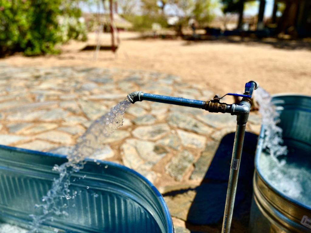 a bucket of water pouring out of a water fountain at Popular Homestead! Location, Stargaze, Views! in Joshua Tree