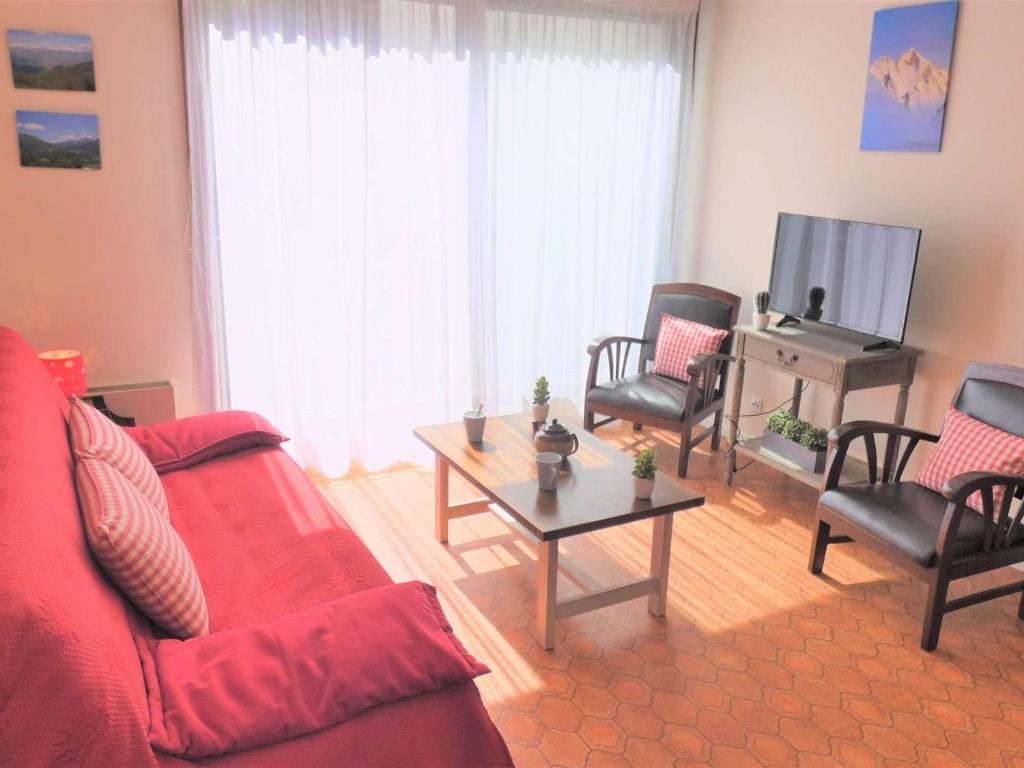 a living room with a red couch and chairs and a tv at Appartement Saint-Lary-Soulan, 2 pièces, 6 personnes - FR-1-457-149 in Saint-Lary-Soulan