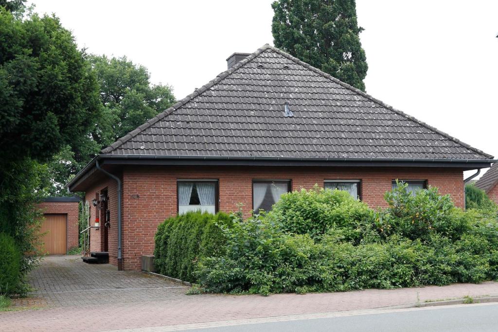 a red brick house with a black roof at Ferienhaus Wedemann 