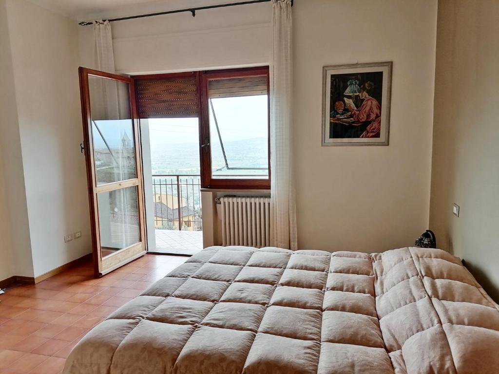 1 dormitorio con cama grande y ventana grande en Il Panorama di Trevi, en Trevi