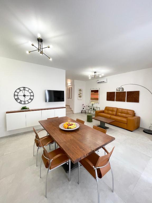 a kitchen and living room with a wooden table and chairs at Casa Le Volte by Ferrocino Holiday in Nardò