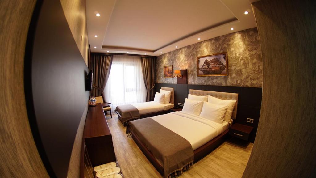 Postel nebo postele na pokoji v ubytování Kahra Otel