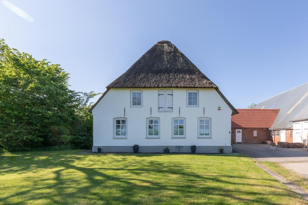 a large white house with a thatched roof at Osterhof in Galmsbüll