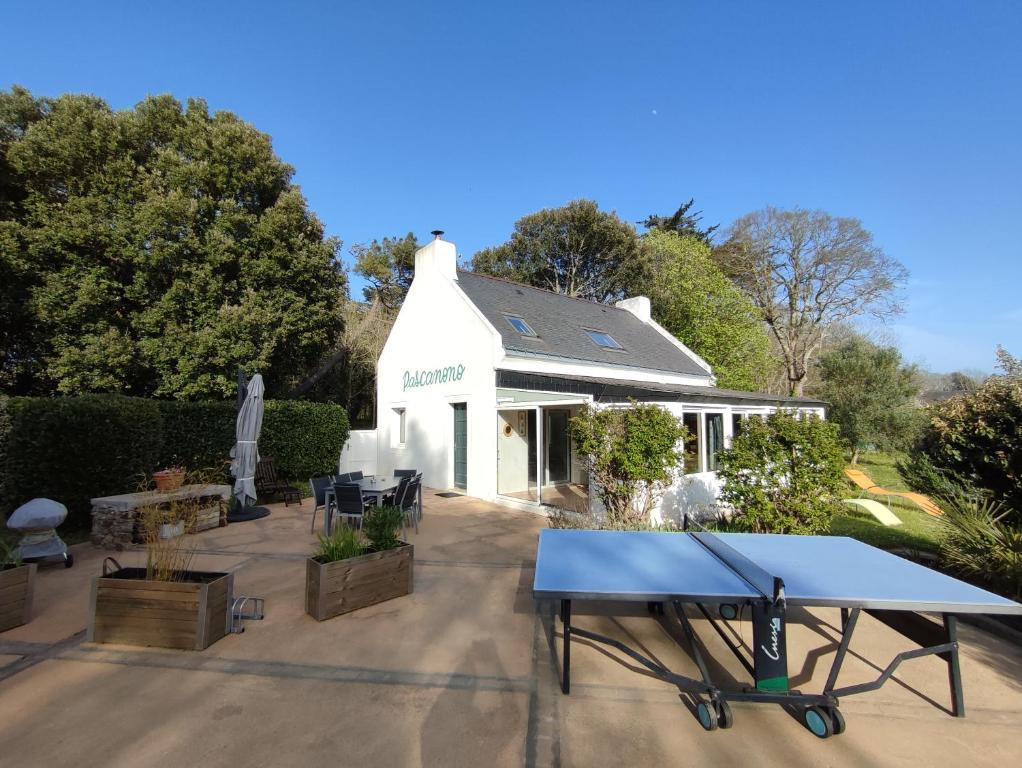 a ping pong table in front of a white house at Pascanono - Location de maison de vacances avec jardin pour séjour à Le Palais, Belle-Ile-en-mer in Le Palais