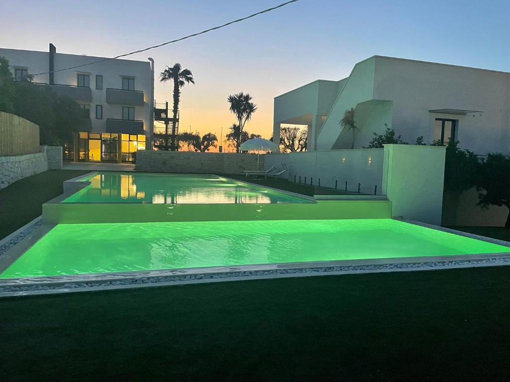 a swimming pool in front of a house at Tuo Hotel in Polignano a Mare