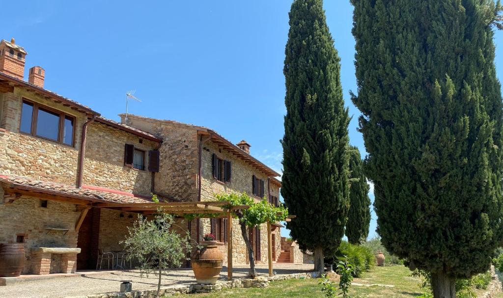 ein Haus mit zwei Bäumen davor in der Unterkunft Tenuta Sovestro in San Gimignano