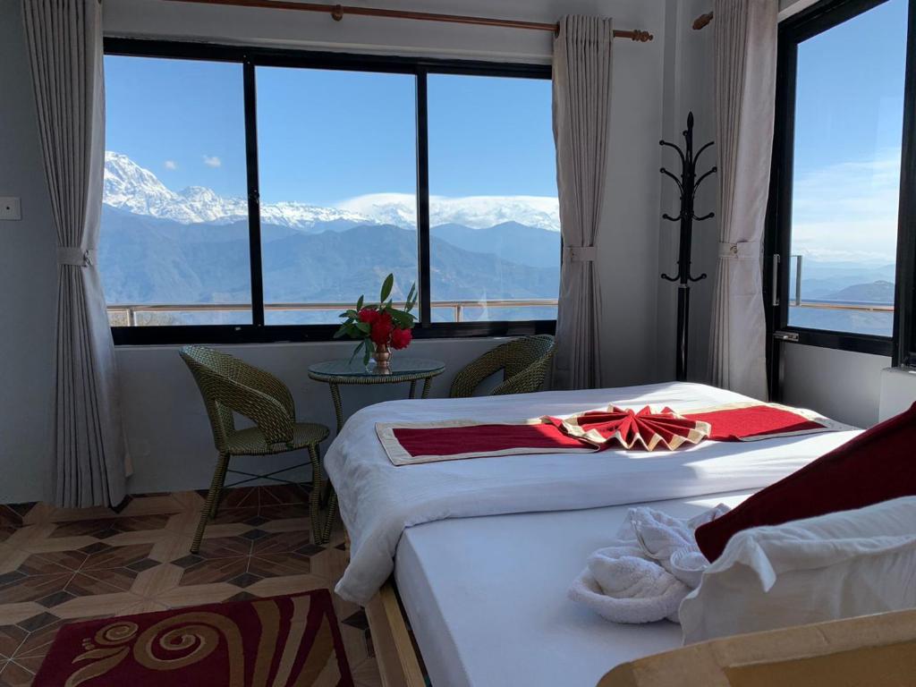 a hotel room with two beds and a view of mountains at Hotel Pristine Himalaya in Pokhara