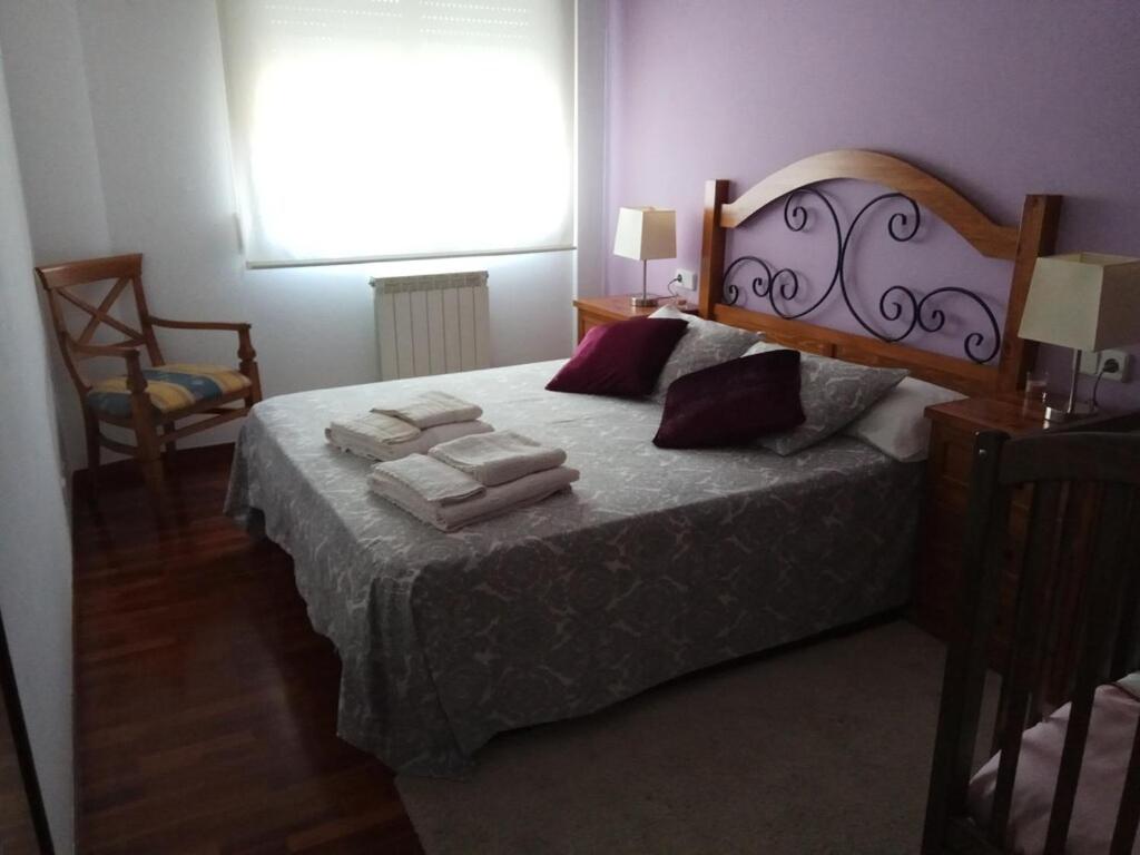 ein Schlafzimmer mit einem Bett mit Handtüchern darauf in der Unterkunft Moderno y luminoso 2 dormitorios con todas las comodidades en Pontevedra ciudad in Pontevedra