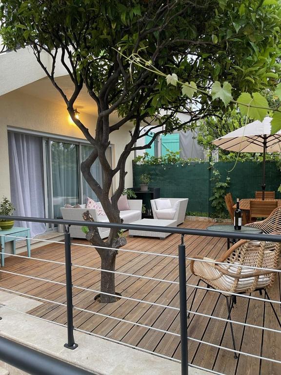 une terrasse avec un arbre, une table et des chaises dans l'établissement 2 pièces en RDJardin avec 2 grands Terrasses, à Antibes