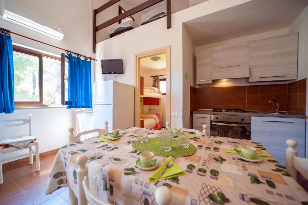 comedor con mesa y cocina en Appartamento Laura en Porto Azzurro