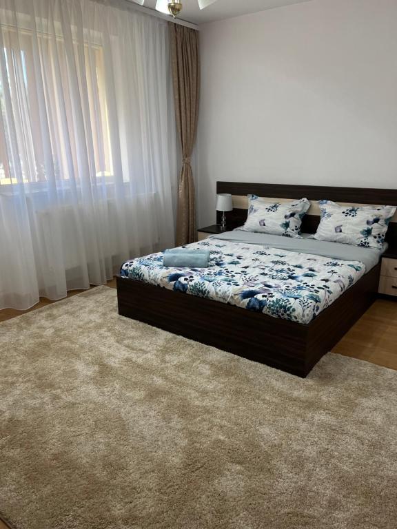 a bedroom with a bed and a large window at Apartament Andrei Baile Felix in Baile Felix