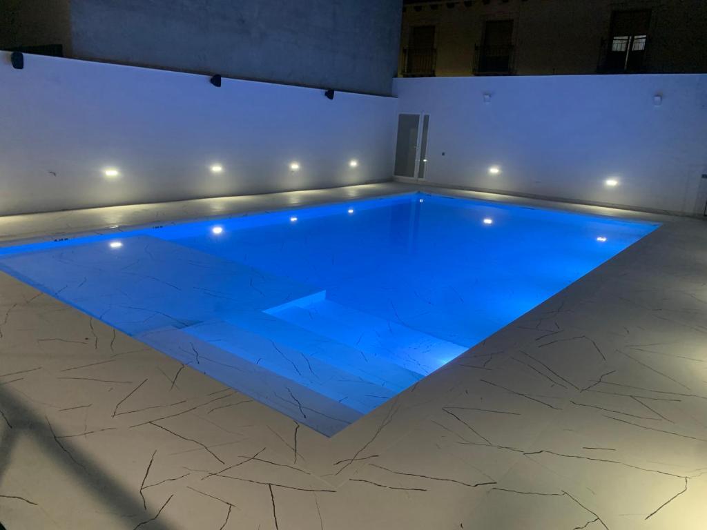 a swimming pool in a room with blue lighting at APARTAMENTO DELUXE in Ossa de Montiel