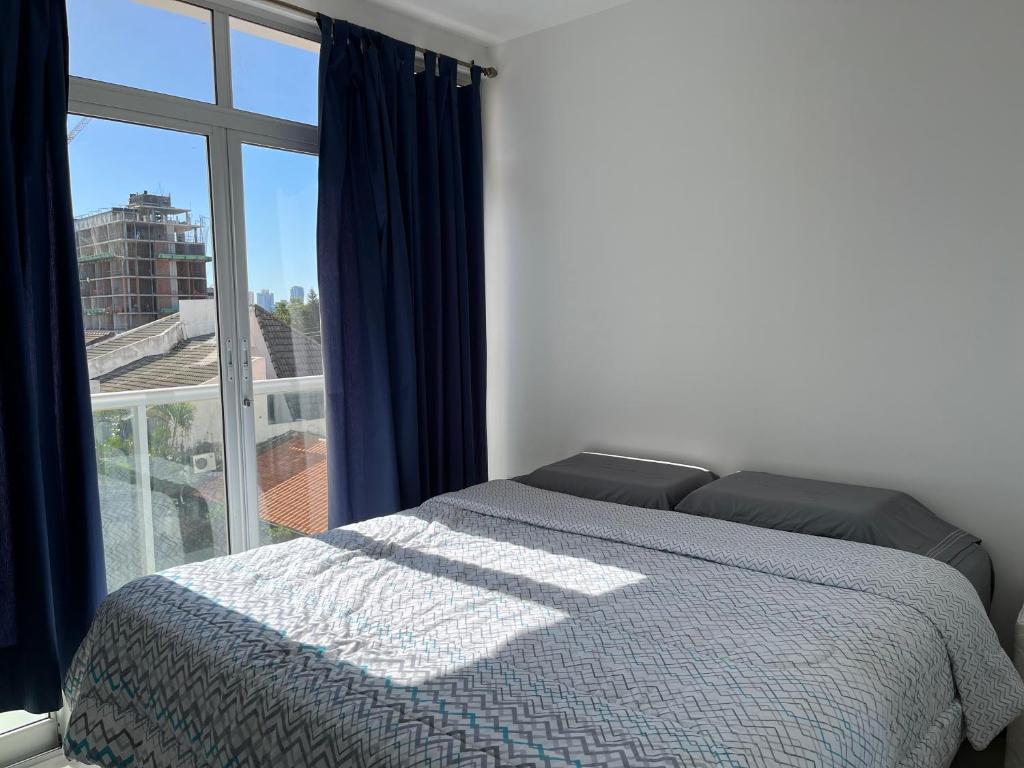 1 dormitorio con cama y ventana grande en Departamento loft con estacionamiento, en Asunción