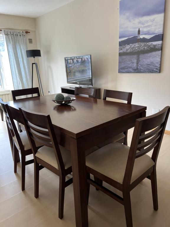 a wooden dining room table with chairs and a table at USHUAIA CALMA Luxury in Ushuaia
