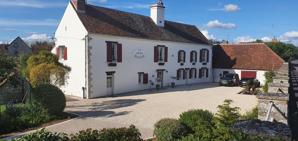 a large white building with red windows and a driveway at Les Bords de Loire in Veuves